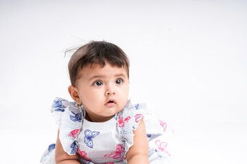 Indian baby girl sitting on white background.