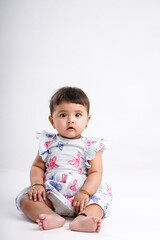 Fototapeta premium Indian baby girl sitting on white background.