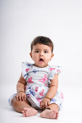 Indian baby girl sitting on white background.