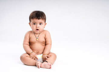 Indian baby girl playing on white background.