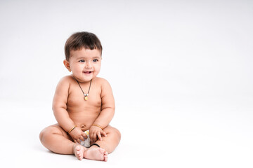 Indian baby girl playing on white background.
