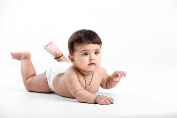 Indian baby girl playing on white background.