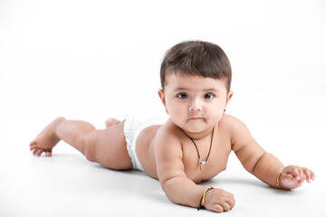 Indian baby girl playing on white background.