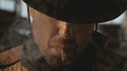 Portrait of cowboy smoking a cigar, old wild west city in the background. Spaghetti, macaroni...