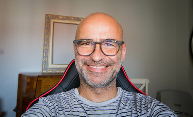 selfy of happy bald man with glasses inside