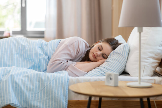 people, bedtime and rest concept - girl sleeping in bed at home in morning