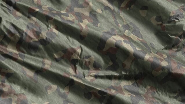 Green army camouflage textile fabric slow waving on the wind background. Full filling seamless slow motion loop.