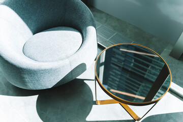 Office interior with armchair and coffee table with sunlight from the window.