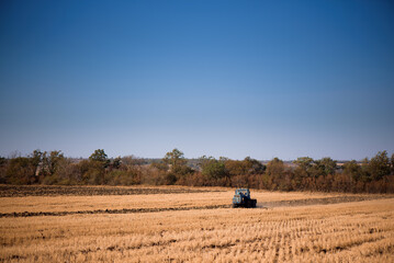 the tractor plows the field in autumn