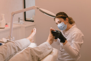 Chiropodist examining the female feet. Healthcare. Woman body care. Spa treatment. - obrazy, fototapety, plakaty