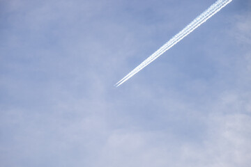 Distant passenger jet plane flying on high altitude on blue sky