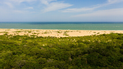 Wild beach and ocean in Kumana national park surrounded by jungle.