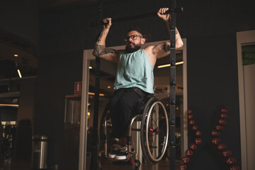 Fototapeta na wymiar A person in a wheelchair inside a gym doing pull-ups to work his lats.