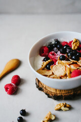 Delicious and healthy breakfast. Natural yogurt, cereals and berries. Wooden spoon.