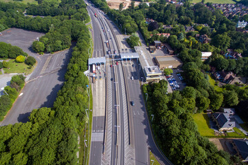 Fototapeta na wymiar aerial view of car and lorry drivers, paying at the toll booth on the north side to cross the Humber Bridge. Hessle. UK