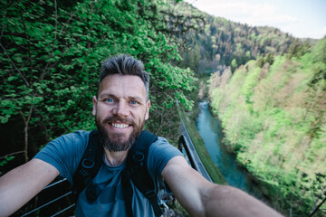 man taking a selfie in the mountains - Powered by Adobe