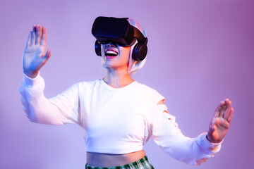 Happy Young asian woman in white sweatshirt wearing black vr headset watching playing and hand...
