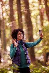 Woman On Hike Through Forest Having Video Call On Mobile Phone