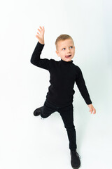 A funny boy in black clothes is dancing on a white background