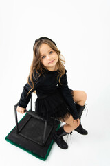 Fototapeta premium A girl in a black blouse and skirt is looking at the camera