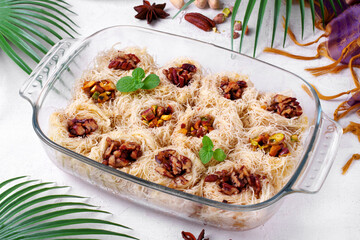 Kunafa dessert made of kataifi dough with pistachio and pecan nuts served in the glass dish. Egyptian cuisine