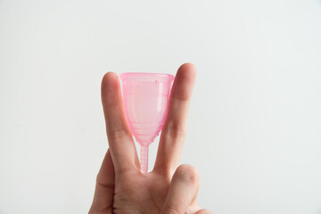 the woman holds a menstrual cup in her hands 