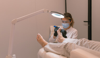 Chiropodist at work. Professional medical pedicure in beauty clinic.