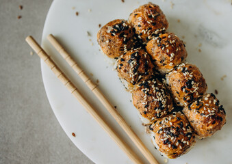 Baked sushi rolls on a marble board for serving
