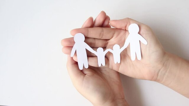 hands holding paper family cut out, family home.