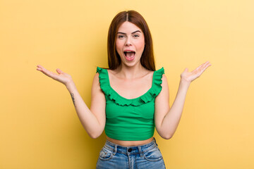 young adult pretty woman feeling happy, excited, surprised or shocked, smiling and astonished at...