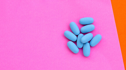 PrEP ( Pre-Exposure Prophylaxis) blue pills used to prevent HIV Blue pills in plastic bottle caps on pink paper surface