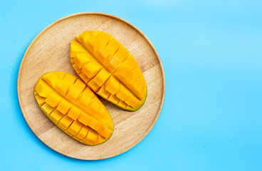 Tropical fruit, Mango in wooden plate on blue background