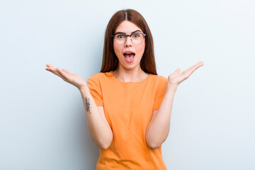 young adult pretty woman feeling happy, excited, surprised or shocked, smiling and astonished at...