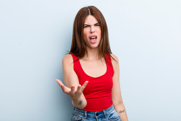 young adult pretty woman looking angry, annoyed and frustrated screaming wtf or what’s wrong with...