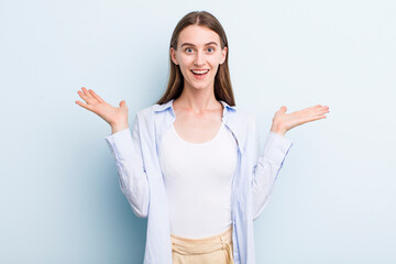 young adult pretty woman feeling happy, excited, surprised or shocked, smiling and astonished at...