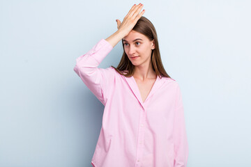 young adult pretty woman raising palm to forehead thinking oops, after making a stupid mistake or...