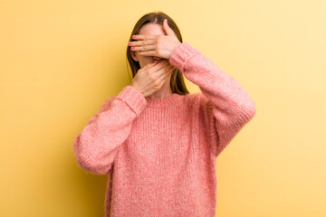 young adult pretty woman covering face with both hands saying no to the camera! refusing pictures...