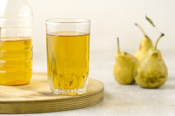 Juice of pears  in a glass on a white wooden background