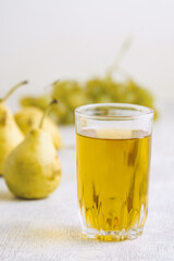 Pears, grapes and juice on white wooden background
