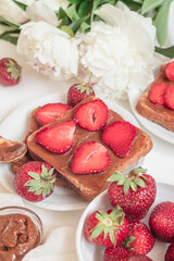 Fresh french toast with fresh red strawberries and chocolate cream for breakfast.