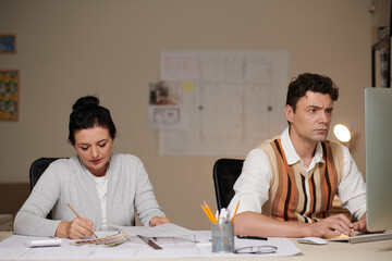Mature experienced architects working at table in modern office