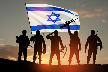 Silhouettes of soldiers with Israel flag against the sunrise in the desert. Concept - armed forces...