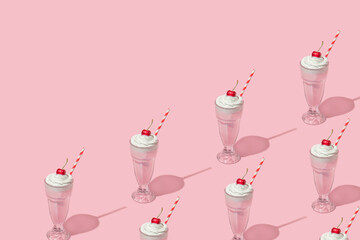 Retro romantic creative pattern with strawberry milkshake glasses with cherry on top on pastel pink...