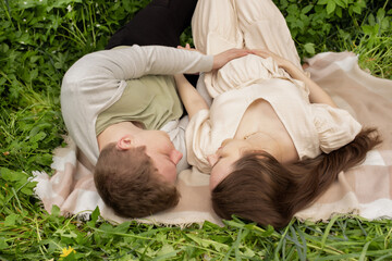 husband hugging pregnant wife. family expecting a baby at a picnic