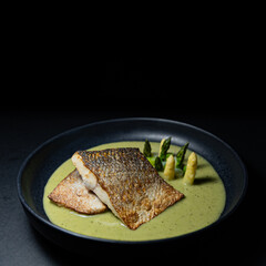 Lubina con curry verde y espárragos con fondo negro