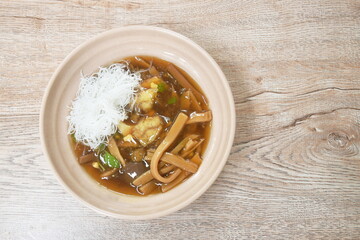 braised fish maw with bamboo shoot topping slice chicken and boiled egg in red gravy soup topping rice vermicelli on bowl
