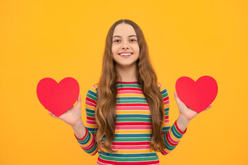 Teenage girl hold shape heart, heart-shape sign. Child holding a red heart love holiday valentine symbol.