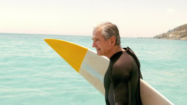 Animation of do it for them over happy caucasian senior male surfer on beach