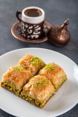 Pistachio baklava on a white plate with Turkish coffee

