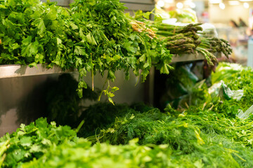 Close-up of fresh parsley, cilantro, dill on the counter in the store. Concept of health and proper nutrition.